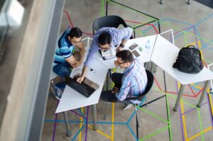 a group of people sitting at a table, troubleshooting their LMS platform